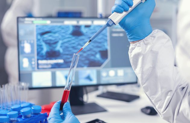 Medical researcher dripping blood into a test tube